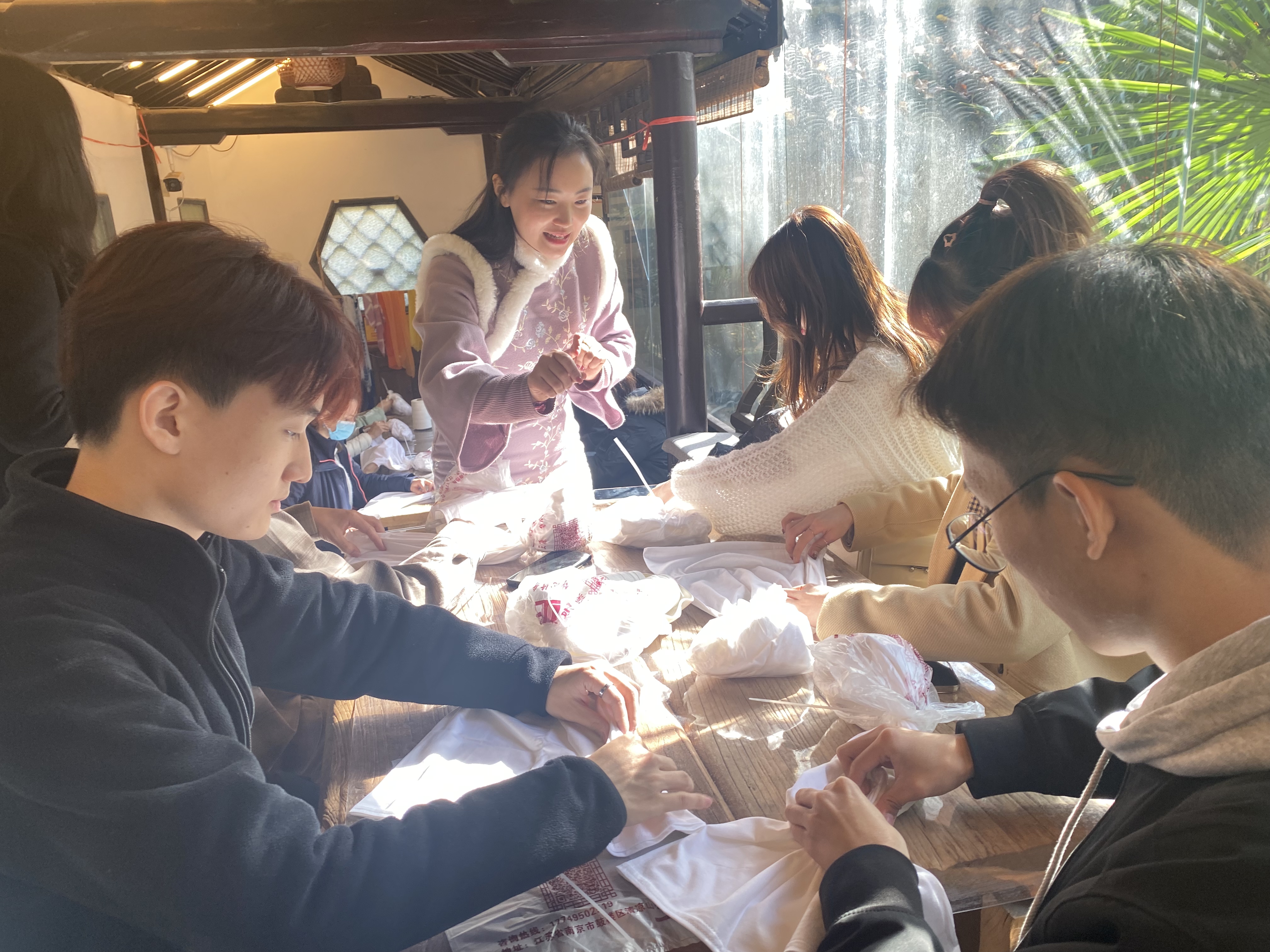 同学们在老师指导下亲自体验扎染技艺